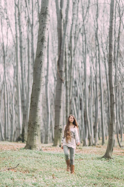Jolie jeune fille aux cheveux longs marchant à travers la forêt verte au printemps — Photo