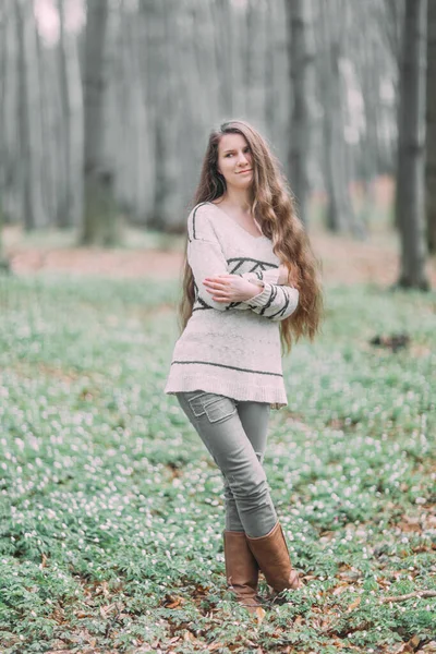 Bonita joven con el pelo largo caminando a través del bosque verde en la primavera — Foto de Stock