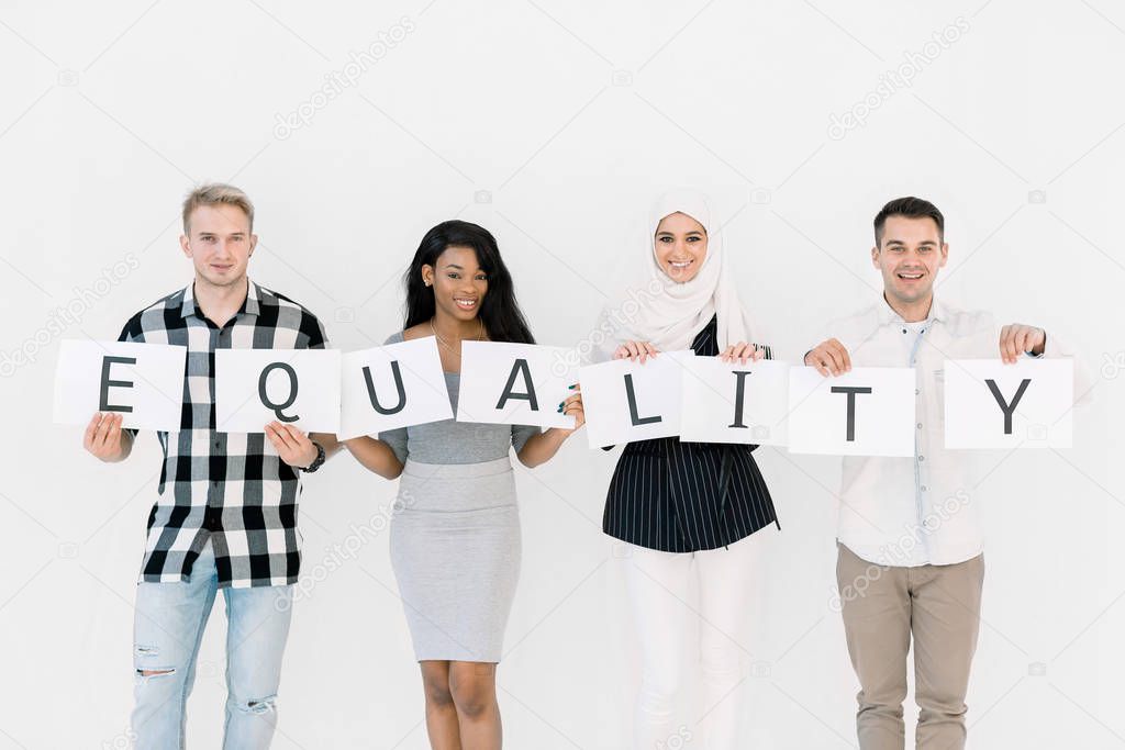 Equality of Races, No racism Concept. Races united against discrimination and racism. Four multiethnical people holding together paper sheets with letters of the word Equality, on the white