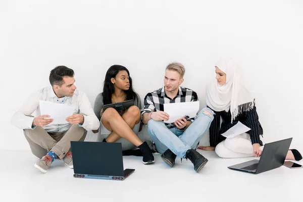 Start-up, entreprise et nouveau concept technologique. jeunes personnes multiethniques travaillant sur ordinateur portable et tablette sur un nouveau projet créatif et de remue-méninges, assis sur le sol isolé sur blanc — Photo