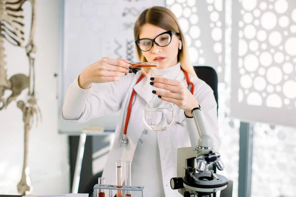 Close-up de médica médica ou jovem cientista trabalhando com ferramentas durante a experiência científica em laboratório. Trabalhadora de laboratório mulher purificando líquido vermelho em frasco, fazendo pesquisa — Fotografia de Stock