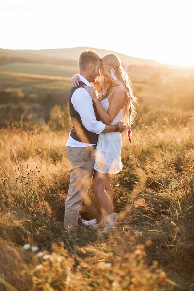 Young hippie boho couple in love outdoors. Portrait of young stylish fashion couple posing in summer in field, hugging and looking each other — Stock Photo, Image