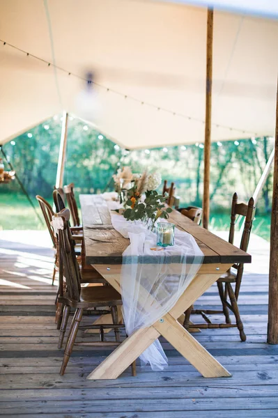 Hochzeits- oder Esstisch, rustikal dekoriert, im Freien im stilvollen Zelt. Empfang unter freiem Himmel, rustikale Hochzeit — Stockfoto