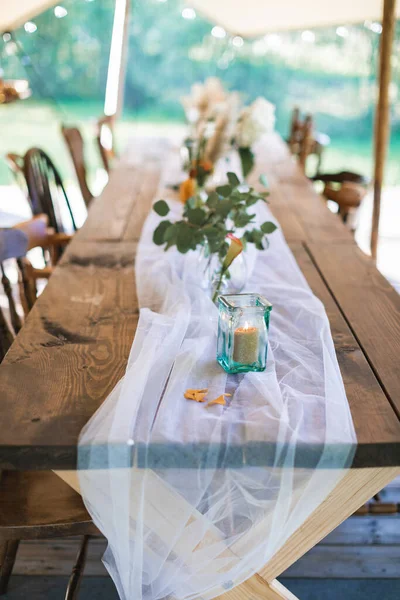 Hochzeits- oder Esstisch, rustikal dekoriert, im Freien im stilvollen Zelt. Empfang unter freiem Himmel, rustikale Hochzeit — Stockfoto