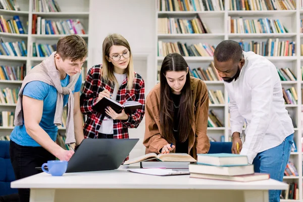 Жіночі та чоловічі багатоетнічні студенти навчаються в бібліотеці коледжу. Навчання та підготовка до іспиту. Концепція освіти . — стокове фото