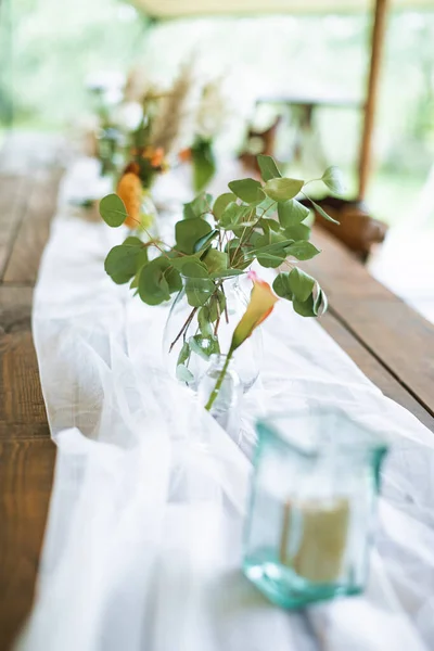 Foto de foco borrada e selecionada da mesa de casamento rústica. Mesa de jantar de madeira vintage com decorações, flores e velas. Estilo Boho. Conjunto de mesa para um evento, festa, data ou casamento ao ar livre — Fotografia de Stock