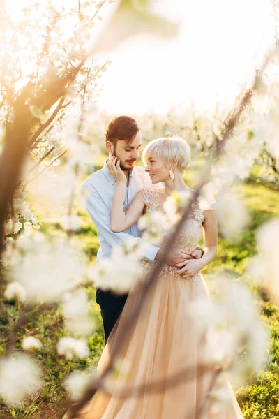 Couple amoureux se tient près de prunier en fleurs dans le jardin dans le jour ensoleillé du printemps, profiter de la date romantique et marcher pendant la saison des fleurs. Couple dans le jardin fleuri — Photo