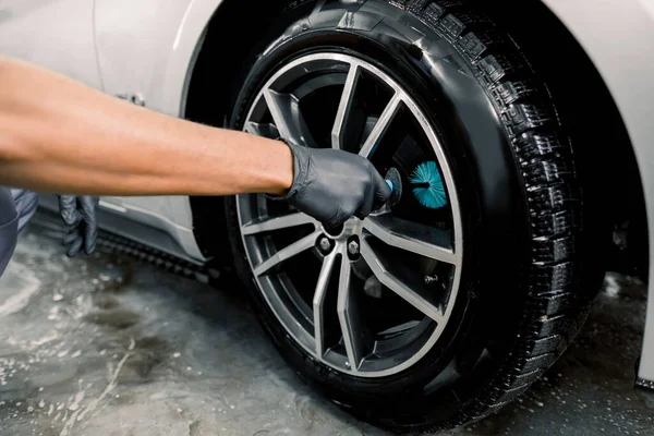 洗车服务。在详细的车辆维修车间里，用一个特殊的铸造轮刷子清洁豪华车的合金轮缘 — 图库照片