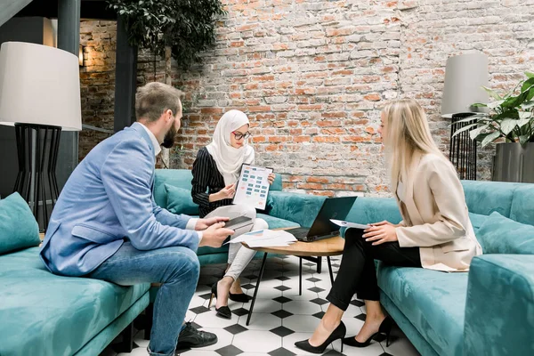 Багаторасова група корпоративних ділових людей, кавказький бородатий чоловік, араб муслім жінка в Білому Хіджабі, блондинка Кавказ, обговорюючи їх спільний бізнес-проект в кімнаті зустрічей. — стокове фото