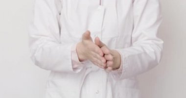 Beyaz önlüklü genç bayan doktor grip salgını, koronavirüs salgını ve bulaşıcı hastalıklar sırasında el dezenfeksiyonu ve temizlik için antibakteriyel el jel uyguluyor.