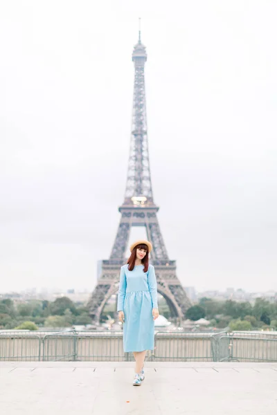 Torre Eiffel a Parigi. Carino felice giovane donna caucasica in abito blu e cappello, sorridente mentre in piedi al punto di vista Trocadero di fronte alla Torre Eiffel, Parigi, Francia — Foto Stock