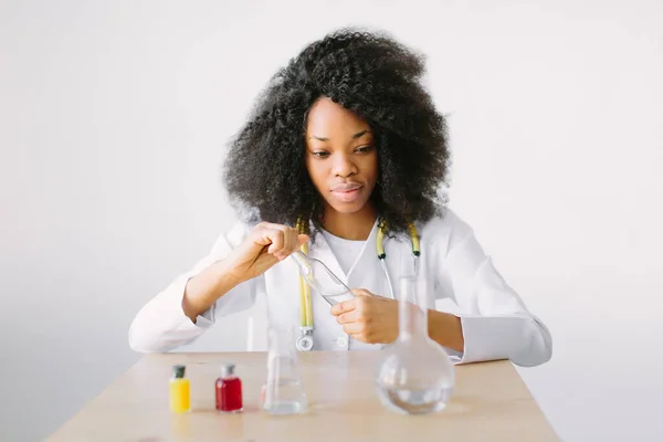 Lab assistant testing water quality. Portrait of a young beautiful African American girl researcher chemistry student carrying out research in a chemistry lab