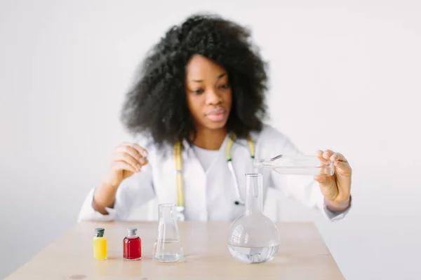 Lab assistant testing water quality. Portrait of a young beautiful African American girl researcher chemistry student carrying out research in a chemistry lab