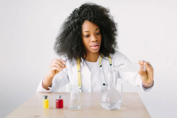 Lab assistant testing water quality. Portrait of a young beautiful African American girl researcher chemistry student carrying out research in a chemistry lab