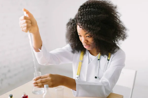 Portrait of a young beautiful African American girl researcher chemistry student carrying out research in a chemistry lab. Scientist analyzing a test-tube. — Stock Photo, Image