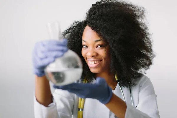 Young beautiful African American girl female with glass equipment in the lab Researcher researching in the laboratory — Stock Photo, Image