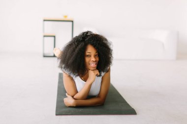 Paspasın üzerinde fiziksel egzersiz yapan Afro-Amerikalı genç bir kadın.