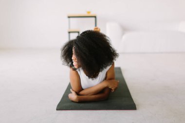 Paspasın üzerinde fiziksel egzersiz yapan Afro-Amerikalı genç bir kadın.