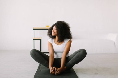 Paspasın üzerinde fiziksel egzersiz yapan Afro-Amerikalı genç bir kadın.