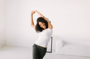 Paspasın üzerinde fiziksel egzersiz yapan Afrikalı bir Amerikalı genç kadın.