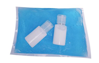 Mikrop ve bakterilerin yayılmasını önlemek ve beyaz arka planda koronavirüs enfeksiyonlarından korunmak için plastik pakete losyon sürün..