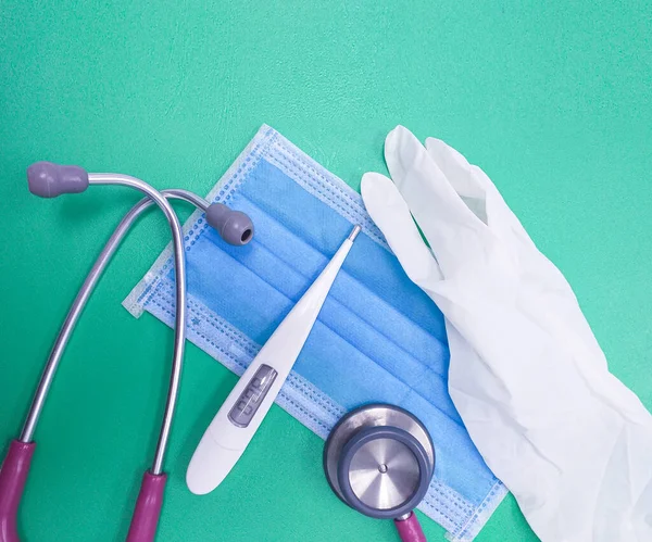 Nahaufnahme Medizinische Geräte Handschuhe Blaue Chirurgenmaske Stethoskop Und Thermometer Auf — Stockfoto