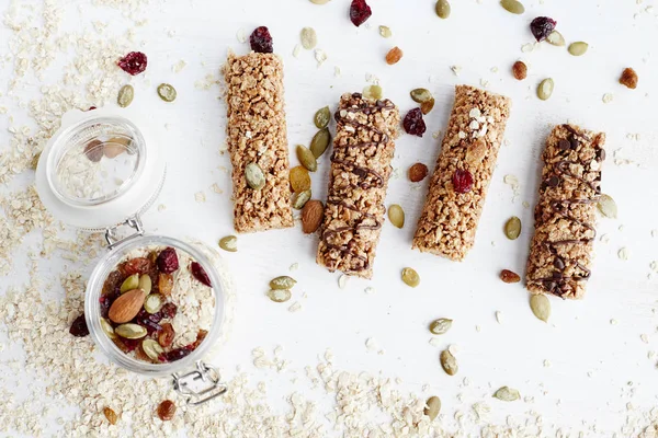 Granola bar. Healthy organic sweet dessert snack. Cereal granola bar with nuts, fruit and berries on a white wooden table. Top view.