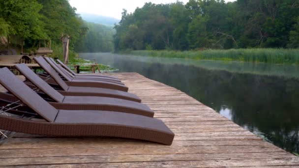 Chaise longues on river — Stock Video