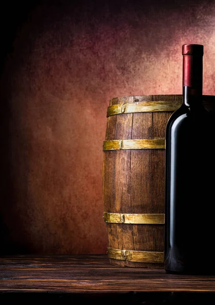 Bottle and barrel on burgundy — Stock Photo, Image