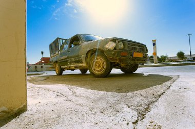 Arka farda kırık bir kamyon var. Arabanın farları ve yıpranmış görünüşü kırılmış. Araba tamir gerektiriyor..