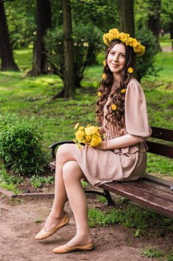 Uzun Üfleme Saçlı Moda Yazı Modeli Kız. Sağlıklı ve güzel, kahverengi saçlı, güneşli arka planda yeşil otlu yaz güzeli kadın.