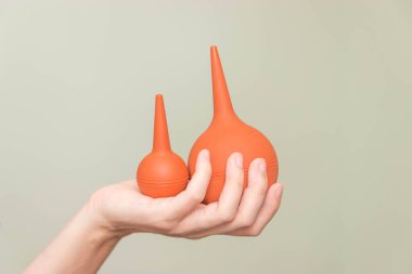 Kadın elinde yumuşak uçlu bir şırınga. Enema bir kadın tutuyor. Tıbbi lavman.