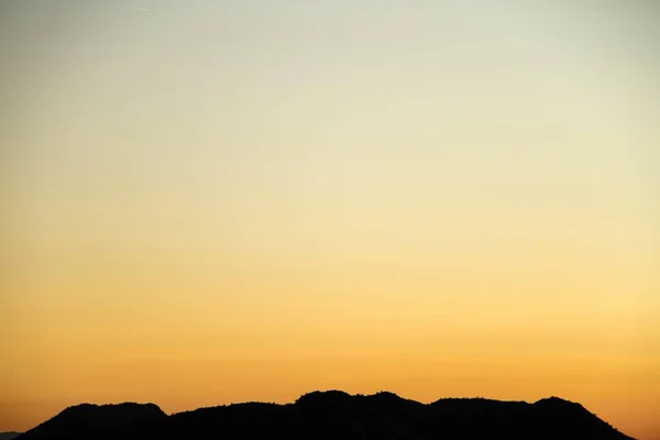 Kopya Alanı Sağlayan Gökyüzü Ile Bir Çöl Dağ Silueti — Stok fotoğraf