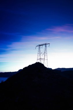 Kayalık bir arazide elektrik kuleleri olan enerji konsepti görüntüsü