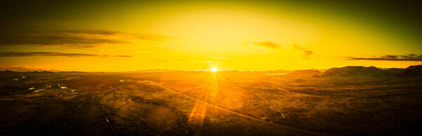 Drone panorama of a sunset over the Sonoran desert of Arizona with partly cloudy skies.