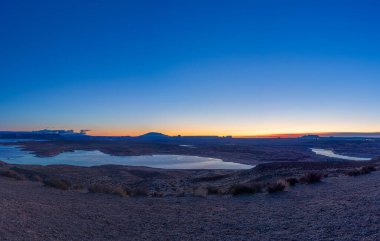 Sabah gökyüzünün panoramik görüntüsü. Powell Gölü önplanda Arizona, Page 'i çevreleyen çorak çölde..