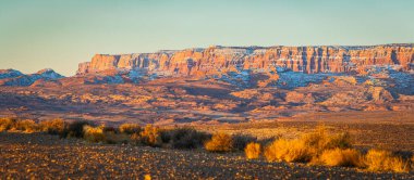 Arizona, Page dışındaki Vermilion Cliffs Ulusal Anıtı 'nın tepelerine vuran sabah ışıklarının panorama görüntüsü.