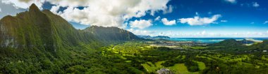 Hawaii 'deki Oahu Adası' ndaki Pali Gözcüsü 'nden panoramik bir hava görüntüsü. Parlak yeşil yağmur ormanları, dikey uçurumlar ve canlı mavi gökyüzü.