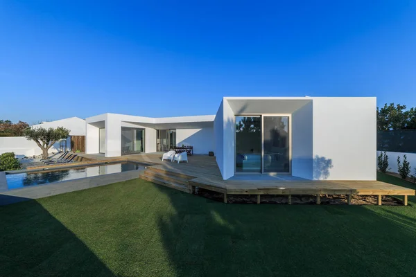 Moderní dům se zahradním bazénem a dřevěnou palubou — Stock fotografie