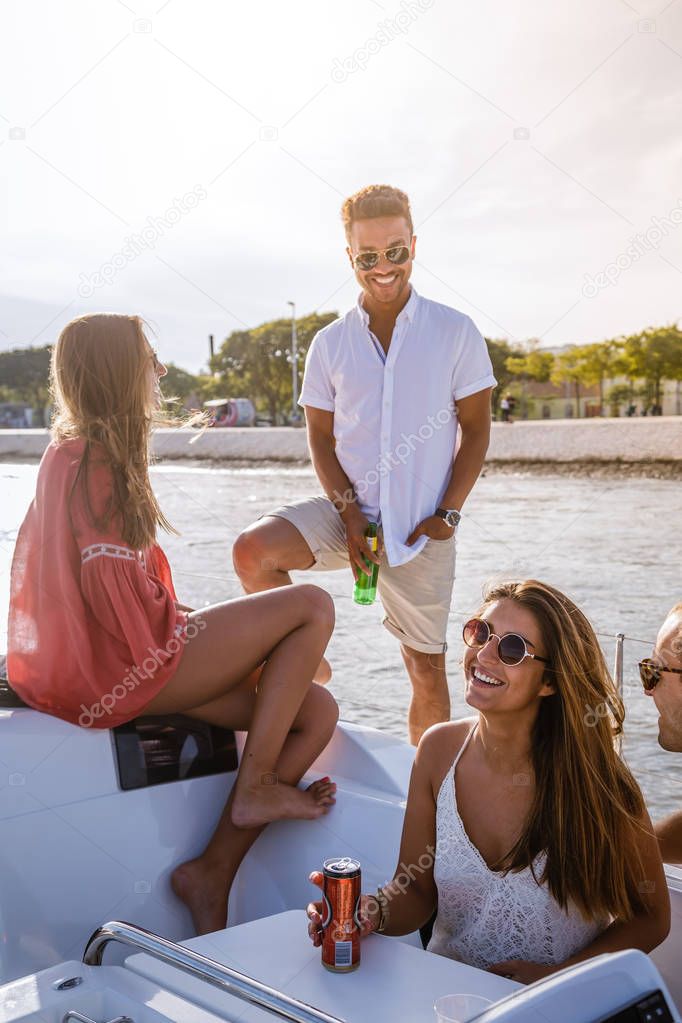Group of friends having fun in boat in river