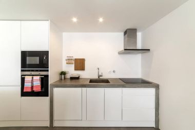 Gri döşemeli ve beyaz duvarlı modern mutfak.