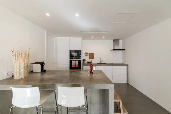 Moderne Küche mit grauem Fliesenboden und weißer Wand - Stockfotografie