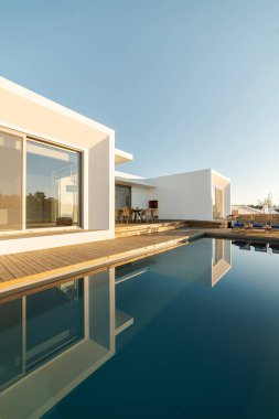 Modern villa üzerinde tahta güverte manzaralı yüzme havuzu