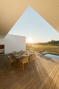 Modern villa terasında bilardo ve güverteli yemek masası.