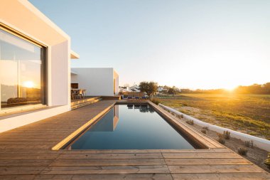 Modern villa üzerinde tahta güverte manzaralı yüzme havuzu