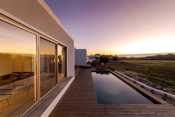 Modern villa üzerinde tahta güverte manzaralı yüzme havuzu