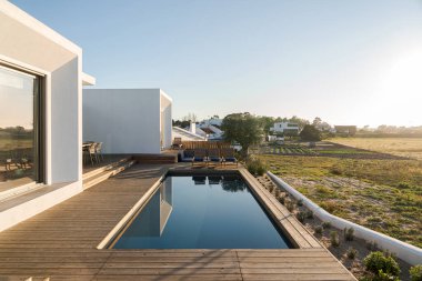 Modern villa üzerinde tahta güverte manzaralı yüzme havuzu