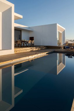 Modern villa üzerinde tahta güverte manzaralı yüzme havuzu