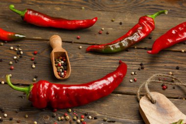 Kırmızı biber ve ahşap doku üzerinde renkli karabiber