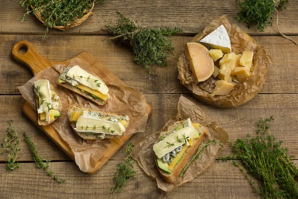 Sándwiches saludables con aguacate, queso y hierbas. En bac de madera — Foto de Stock